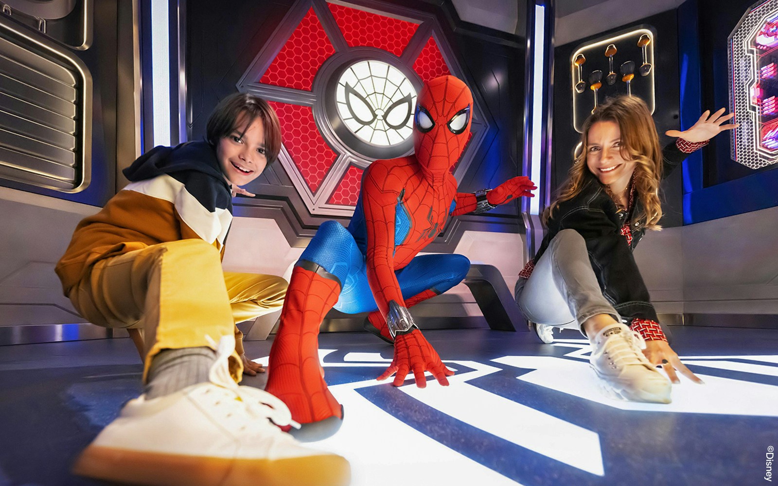 Spider-Man posing with visitors at Disneyland Paris attraction.