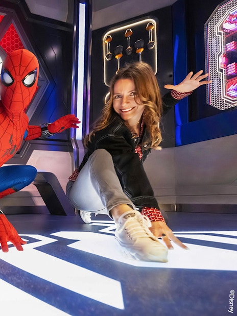Spider-Man posing with visitors at Disneyland Paris attraction.