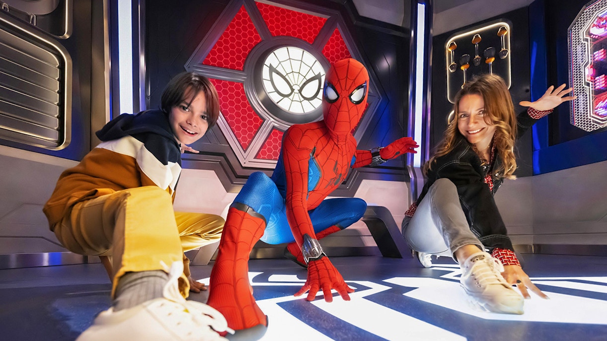 Spider-Man posing with visitors at Disneyland Paris attraction.