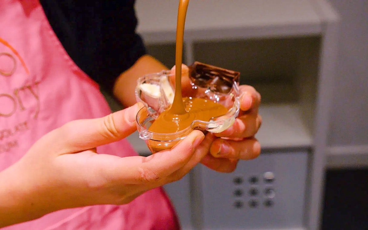 Pouring chocolate into a mold at Choco-Story Paris.