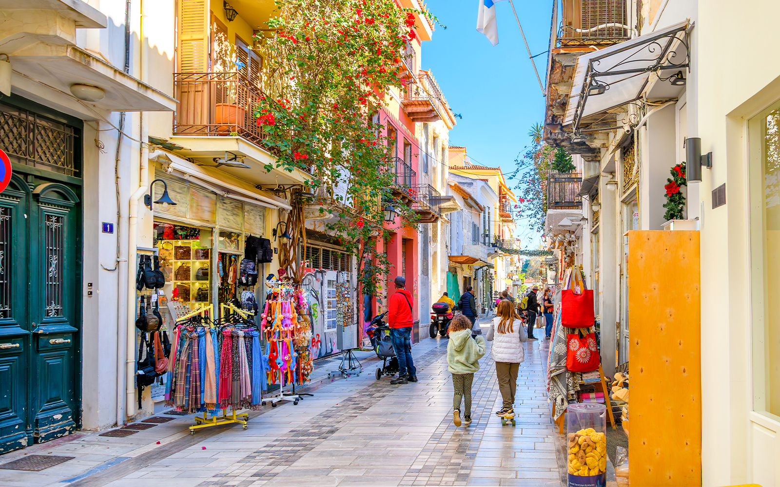 Narrow street with shops and cafes in Nafplio's old town, Greece.