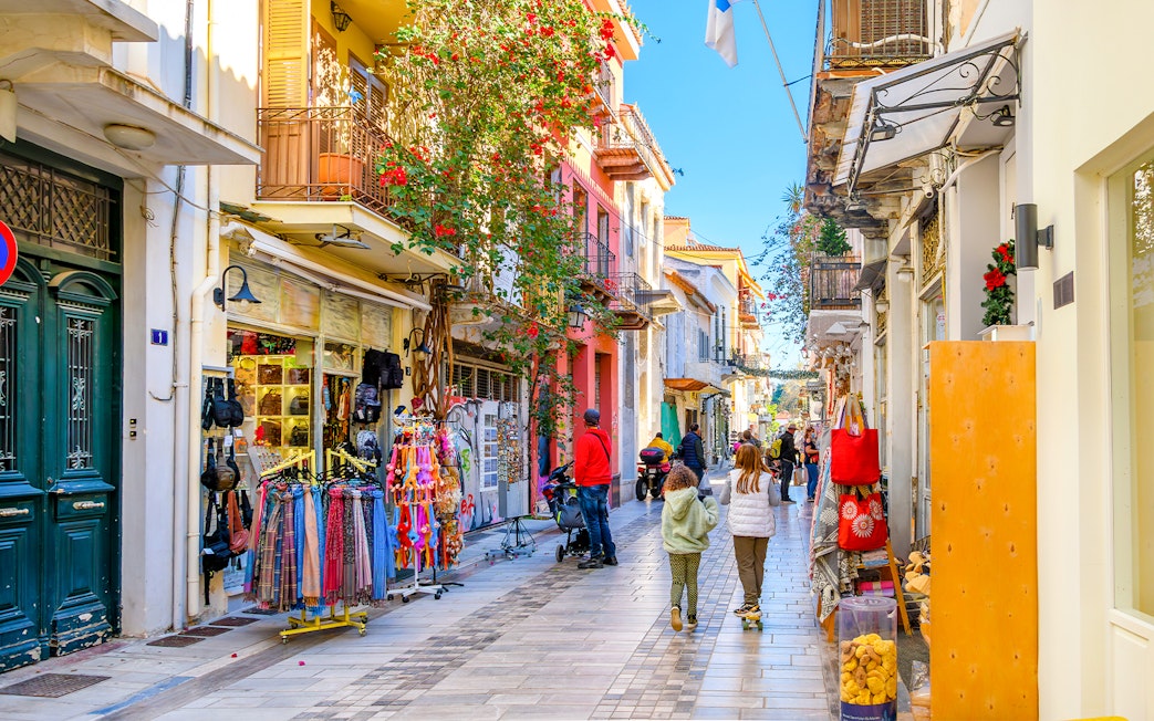 Narrow street with shops and cafes in Nafplio's old town, Greece.