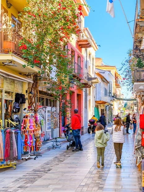 Narrow street with shops and cafes in Nafplio's old town, Greece.