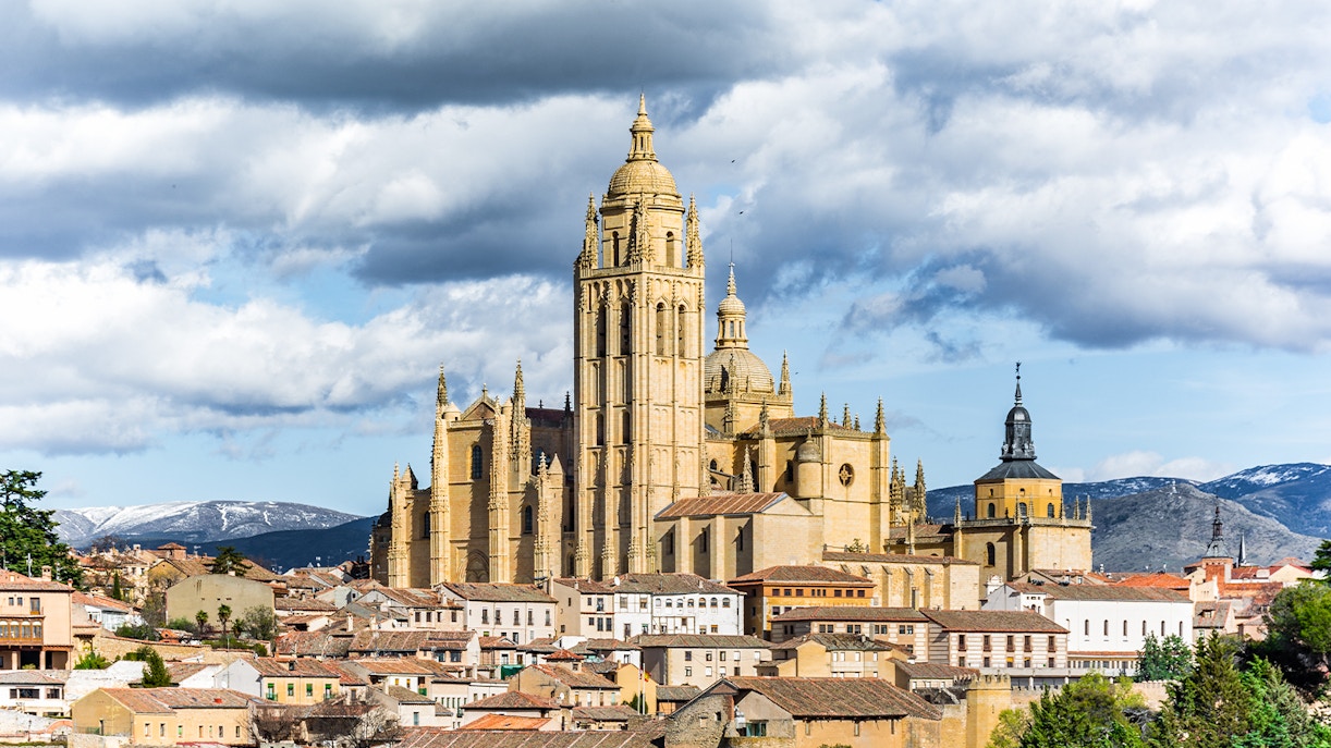 Segovia Cathedral with surrounding cityscape and mountains in the background.