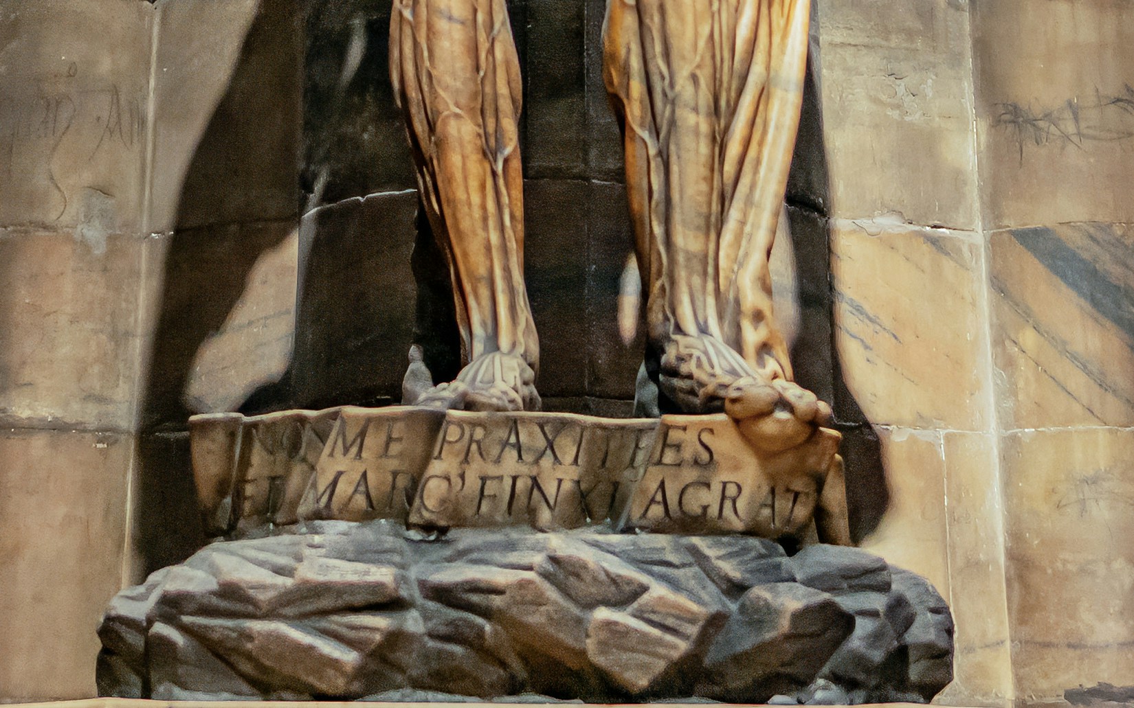 Saint Bartholomew statue detail in Duomo Milan, showing base inscription.