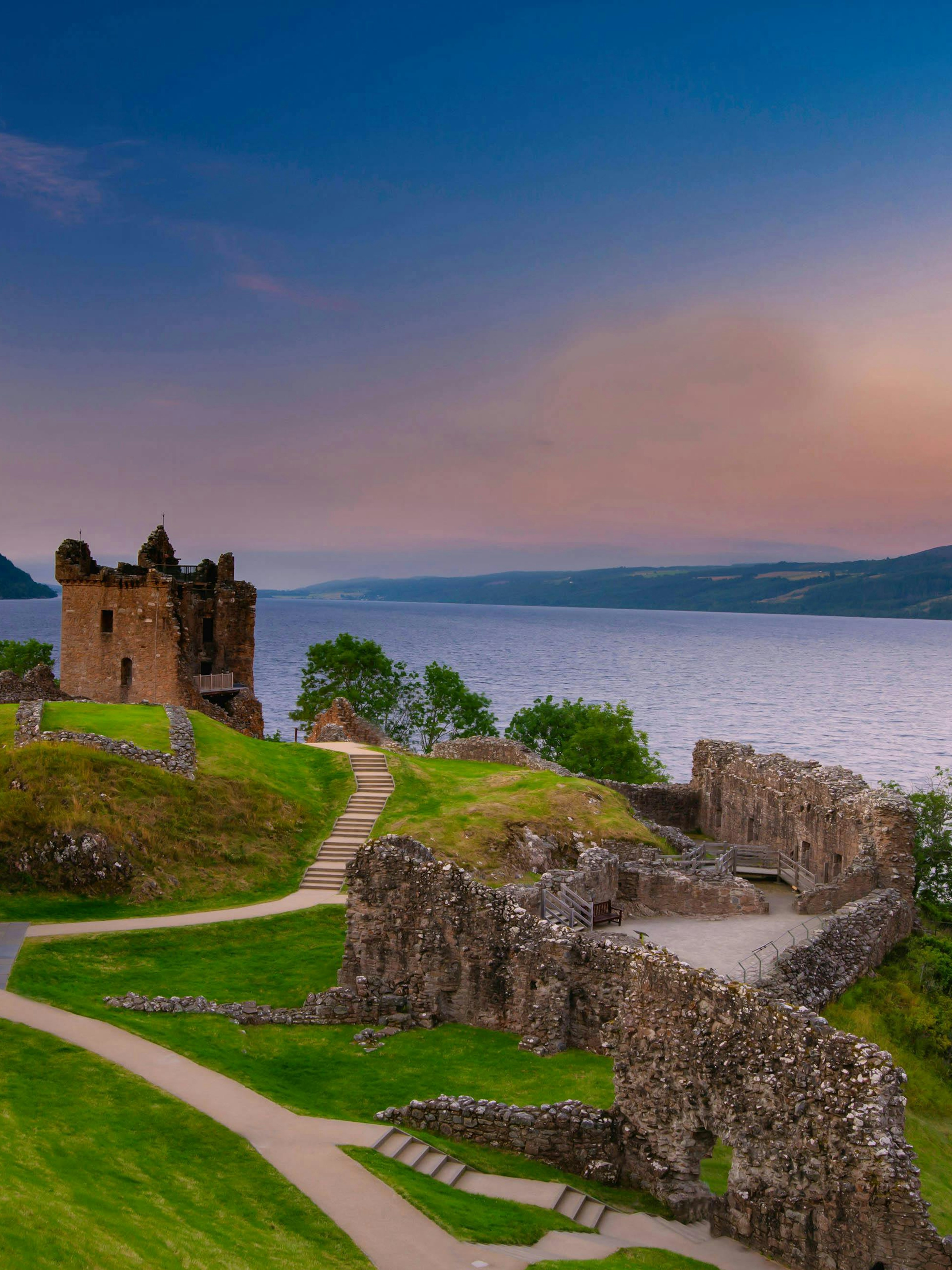 Urquhart Castle ruins overlooking Loch Ness at sunset, Scotland.