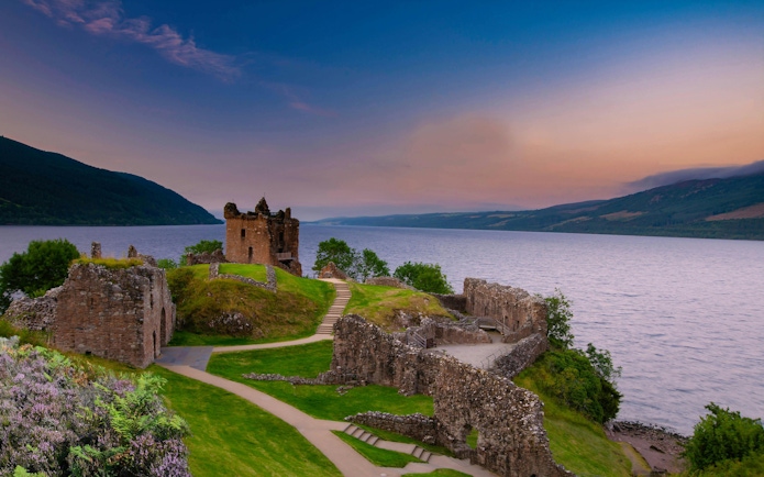 Urquhart Castle ruins overlooking Loch Ness at sunset, Scotland.