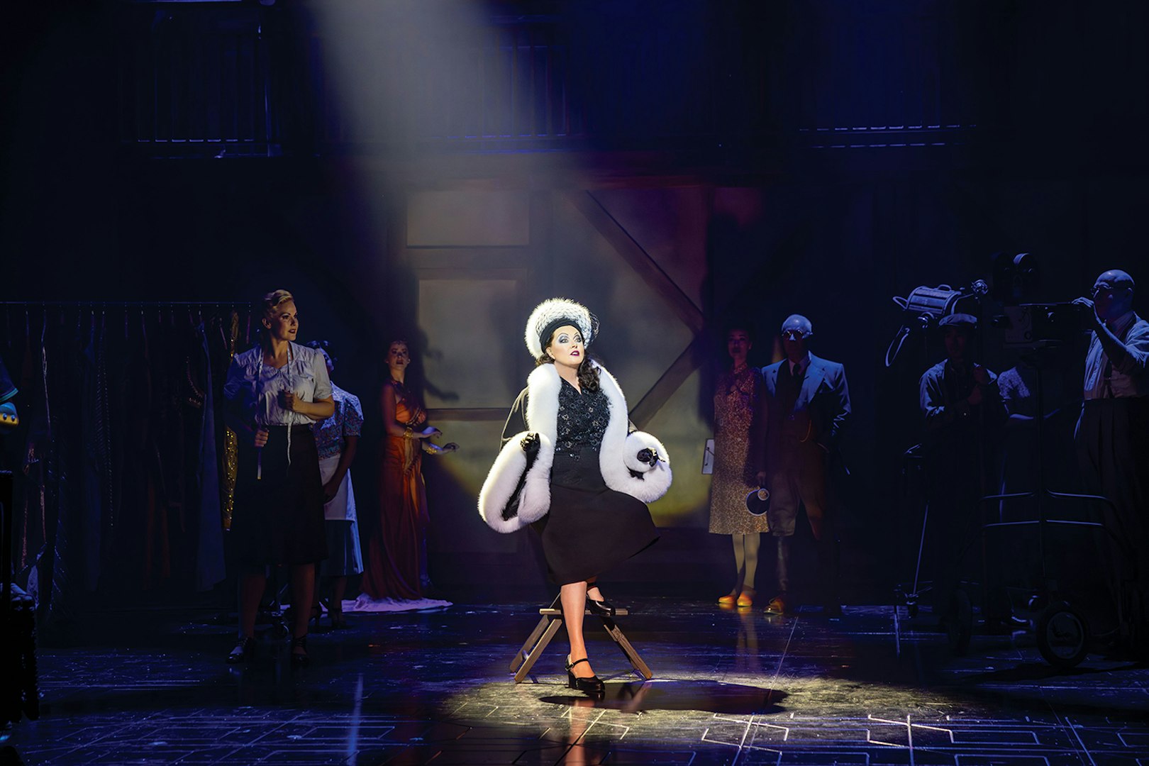 Performer in spotlight on stage during Sunset Boulevard show.