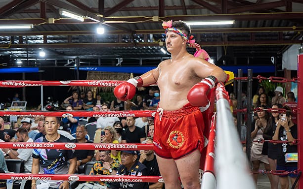 Muay Thai fighter in red shorts and gloves at Rawai Muay Thai Boxing Camp, Phuket.