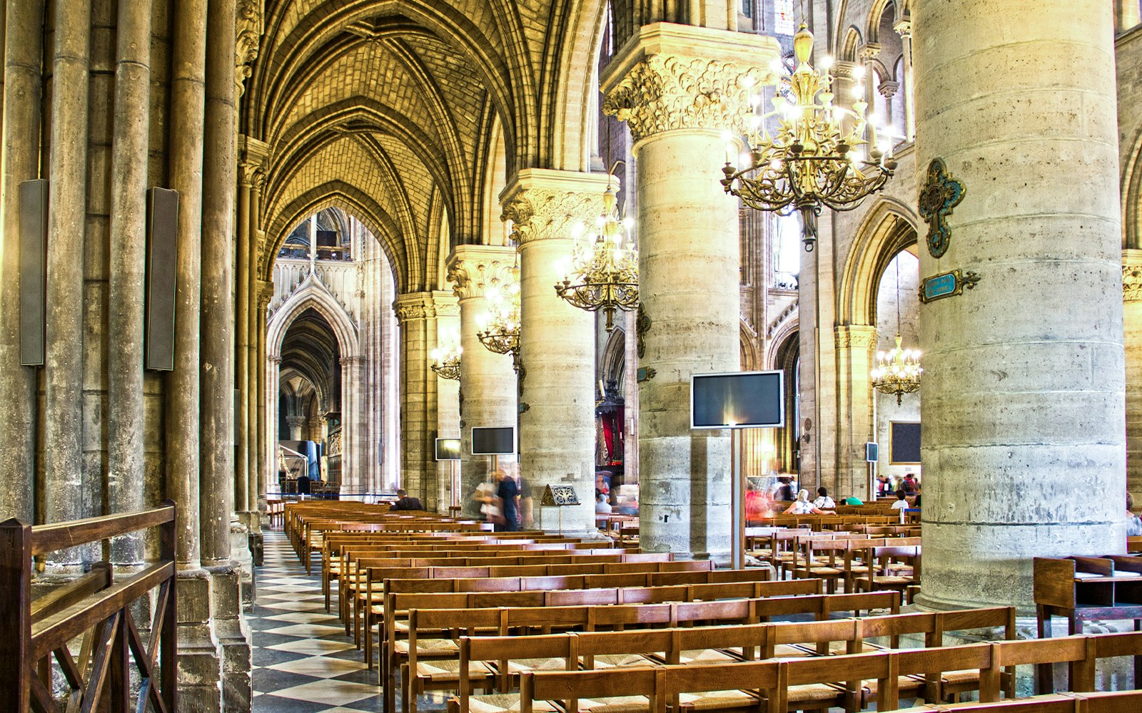 Notre Dame Cathedral nave interior with vaulted ceilings and stained glass windows, Paris.