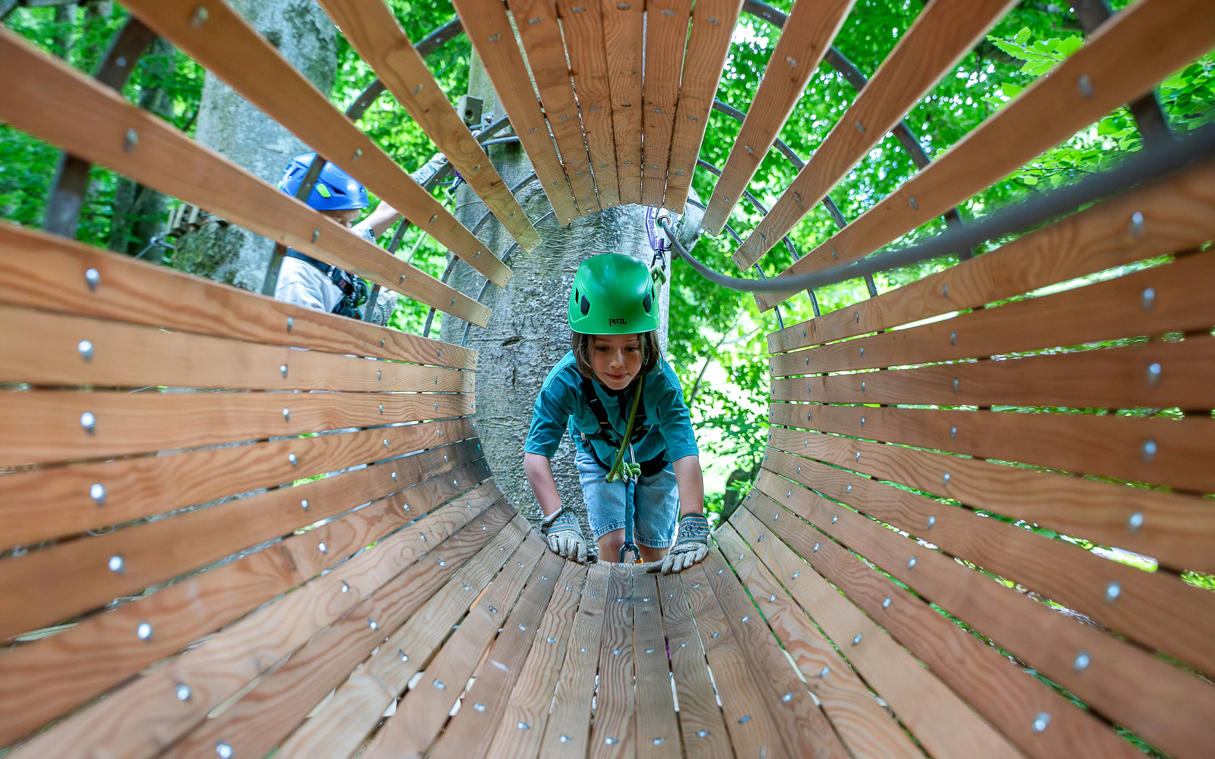 Child navigating wooden tunnel at Ropes Park Interlaken.