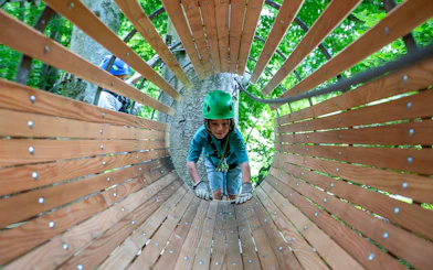 Child navigating wooden tunnel at Ropes Park Interlaken.