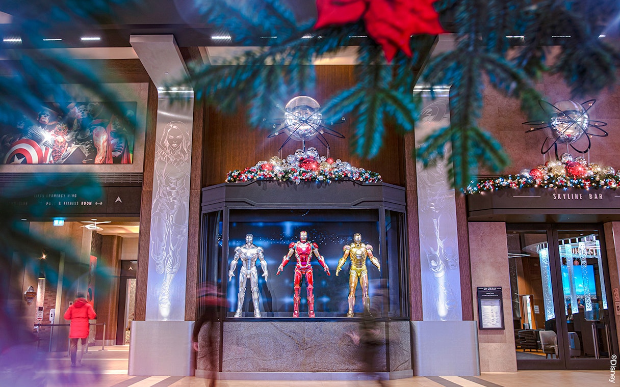 Iron Man suits display at Disneyland Paris during Christmas 2025, with festive decorations.