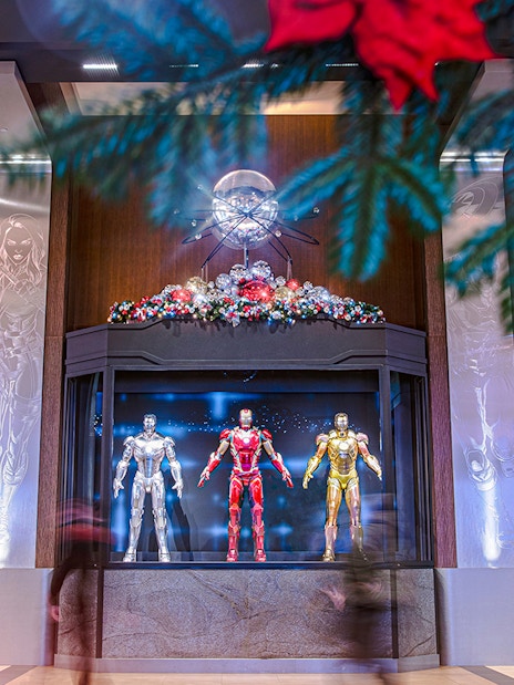 Iron Man suits display at Disneyland Paris during Christmas 2025, with festive decorations.