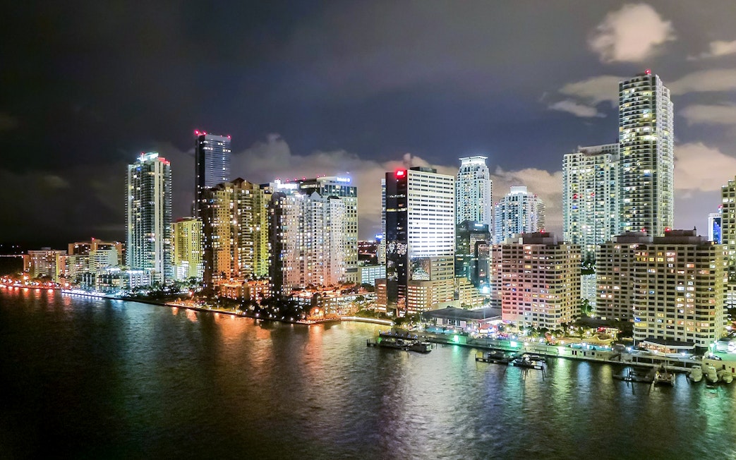 Miami skyline at night viewed from a luxury yacht on the Millionaire's Homes cruise.