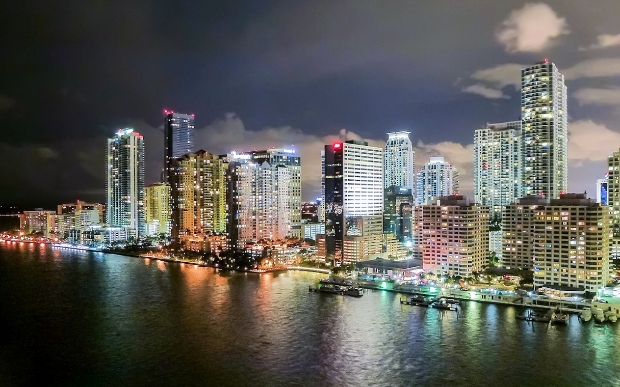 Miami skyline at night viewed from a luxury yacht on the Millionaire's Homes cruise.