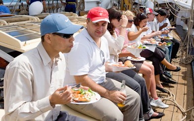 People enjoying a meal on a tall ship cruise on Sydney Harbour.