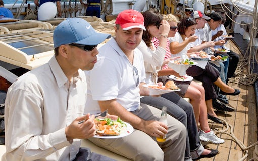 People enjoying a meal on a tall ship cruise on Sydney Harbour.
