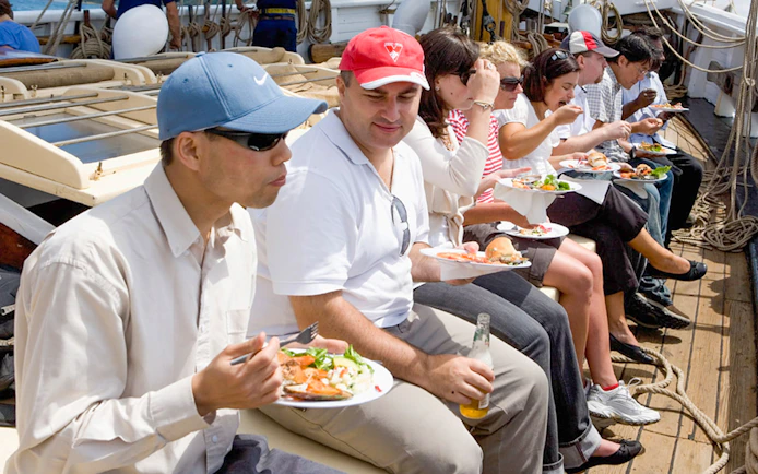 People enjoying a meal on a tall ship cruise on Sydney Harbour.