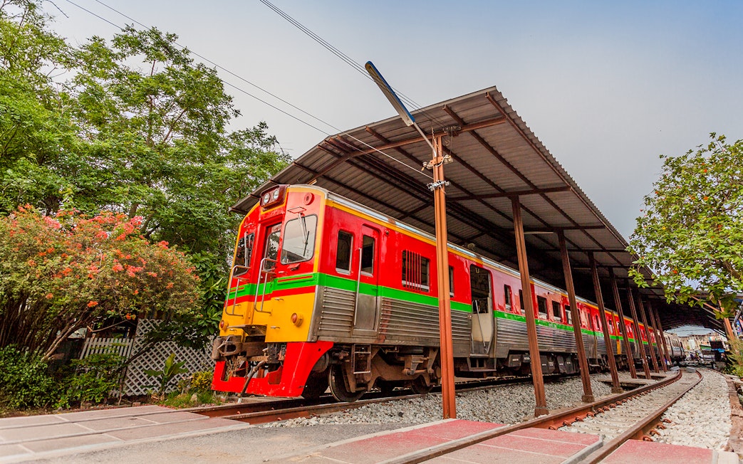 Train passing through Maeklong Railway Market, Thailand.