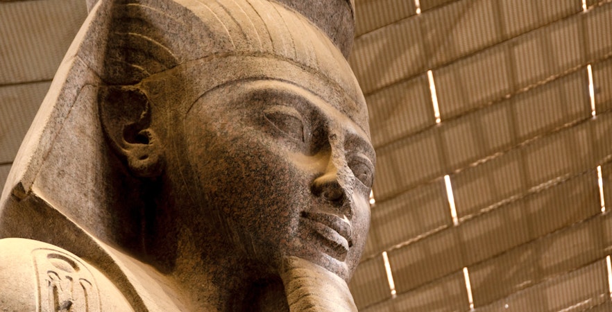 Colossal statue of Pharaoh Ramesses II in Grand Egyptian Museum atrium.
