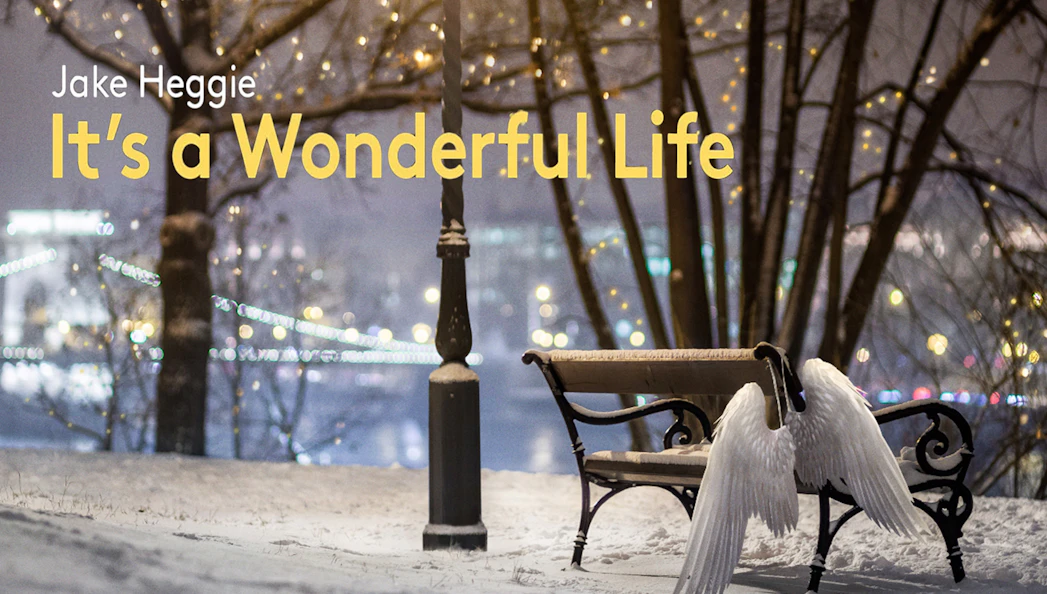 Snowy park scene with angel wings on a bench, lights in the background, "It's a Wonderful Life" text.