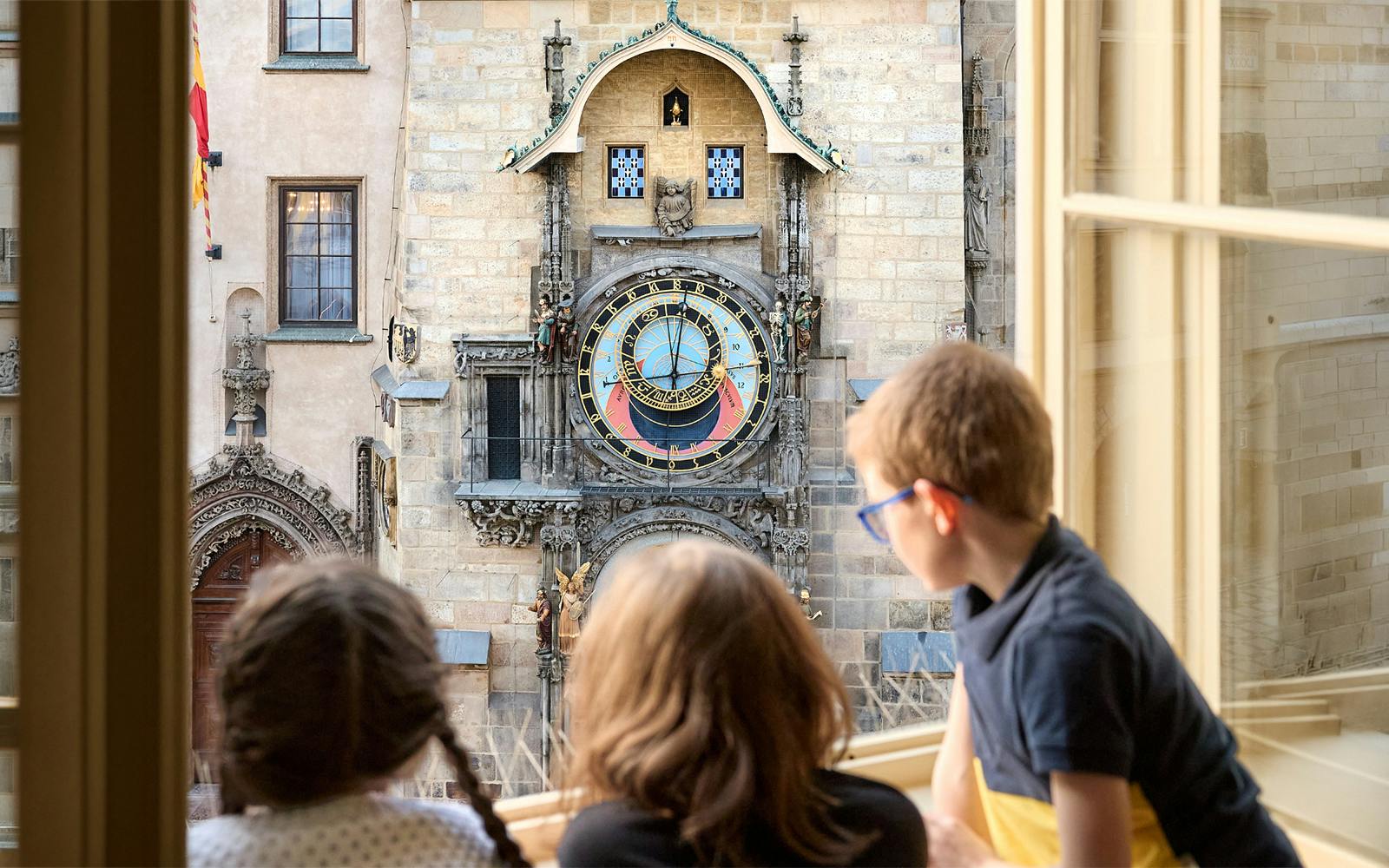 Children viewing Prague Astronomical Clock from a window at the Mozart Interactive Museum.