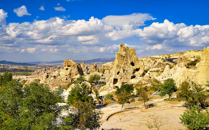 Goreme Open Air Museum rock formations under a blue sky in Cappadocia, Turkey.