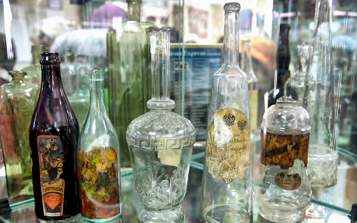 Antique glass bottles displayed in a Warsaw museum exhibit.