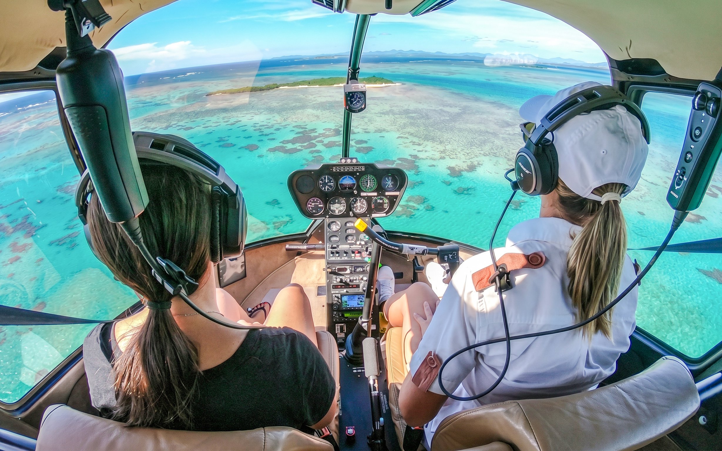 Helicopter cockpit view over turquoise waters during a private tour in Monaco.