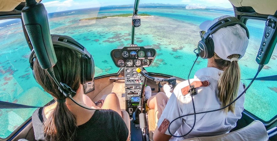 Helicopter cockpit view over turquoise waters during a private tour in Monaco.