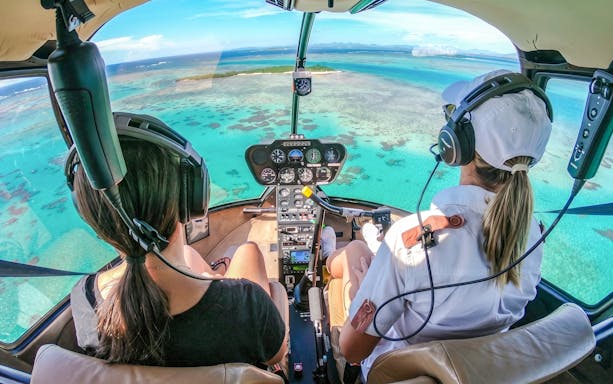 Helicopter cockpit view over turquoise waters during a private tour in Monaco.