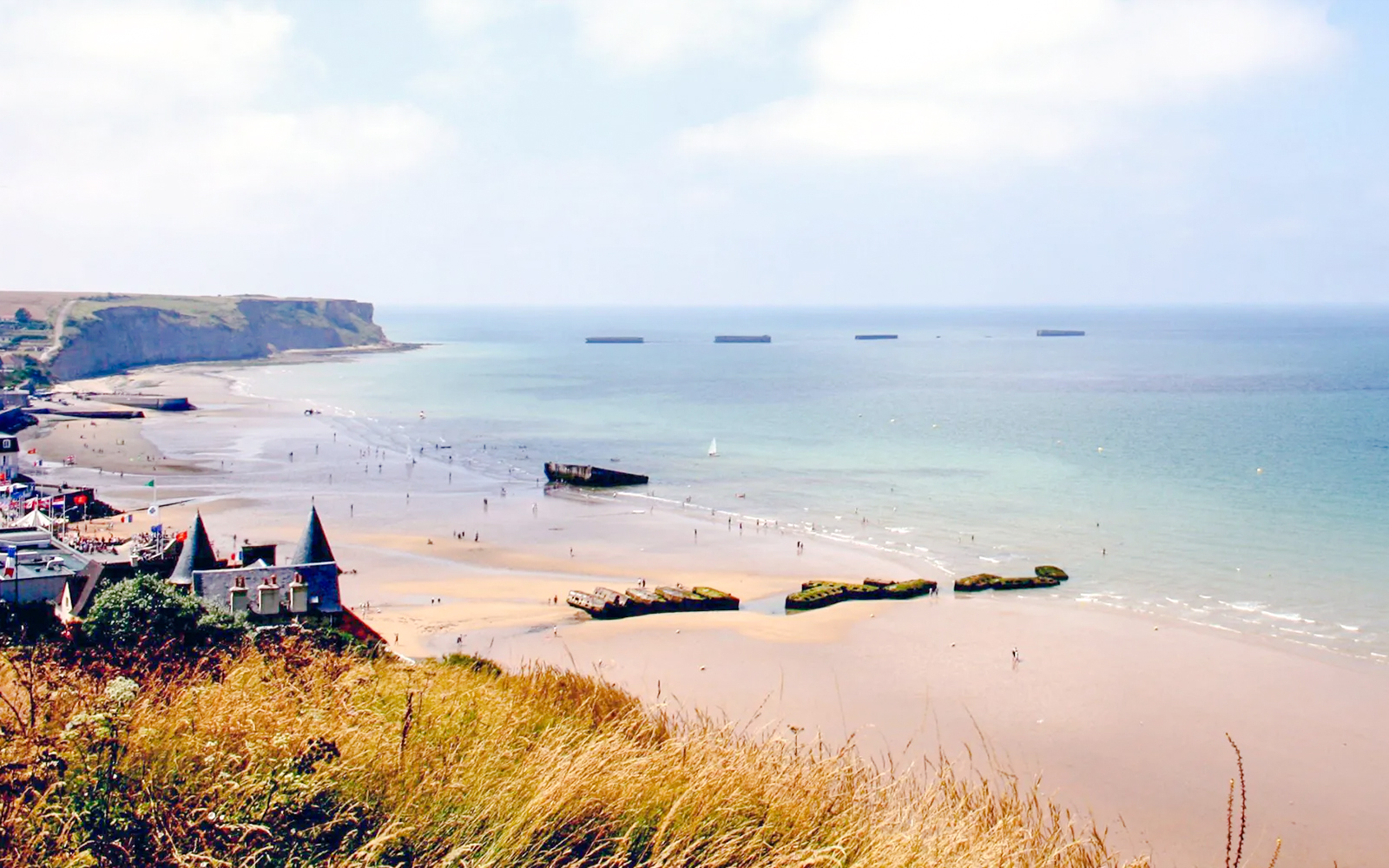 Gold Beach shoreline with remnants of WWII Mulberry Harbour, Arromanches-les-Bains, Normandy.