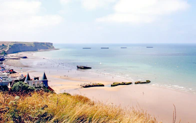Gold Beach shoreline with remnants of WWII Mulberry Harbour, Arromanches-les-Bains, Normandy.