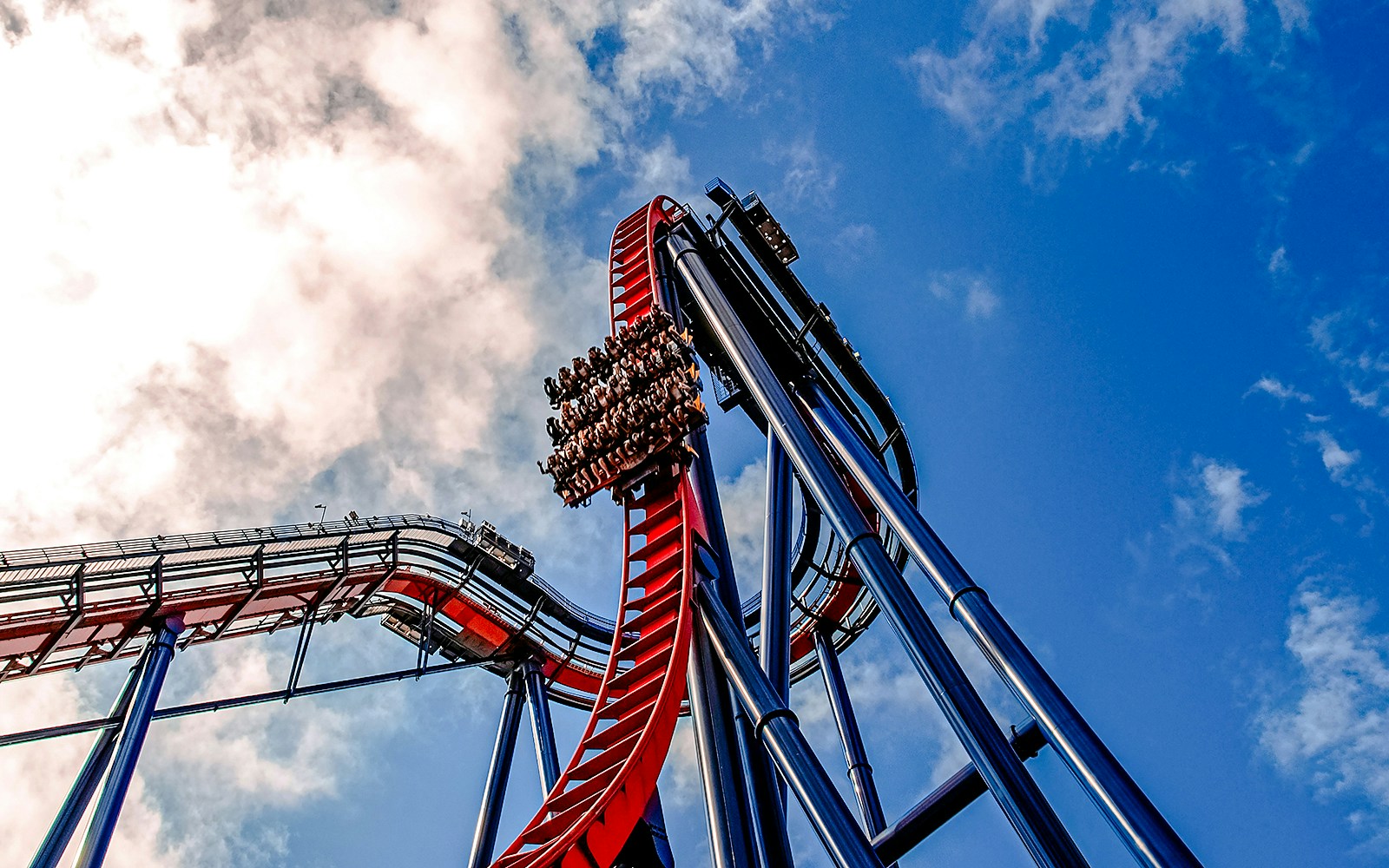 Roller coaster descent at Busch Gardens against a blue sky.