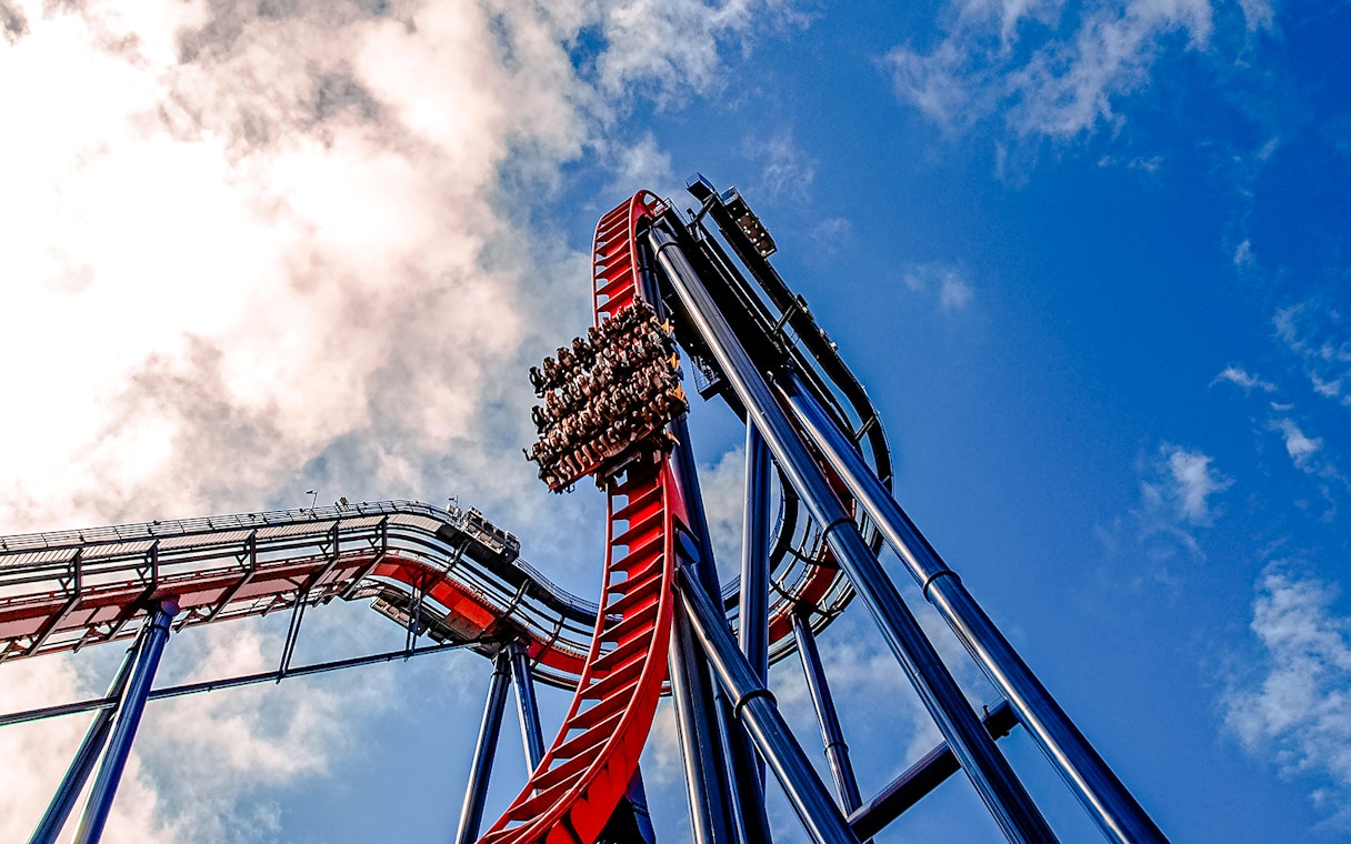 Roller coaster descent at Busch Gardens against a blue sky.
