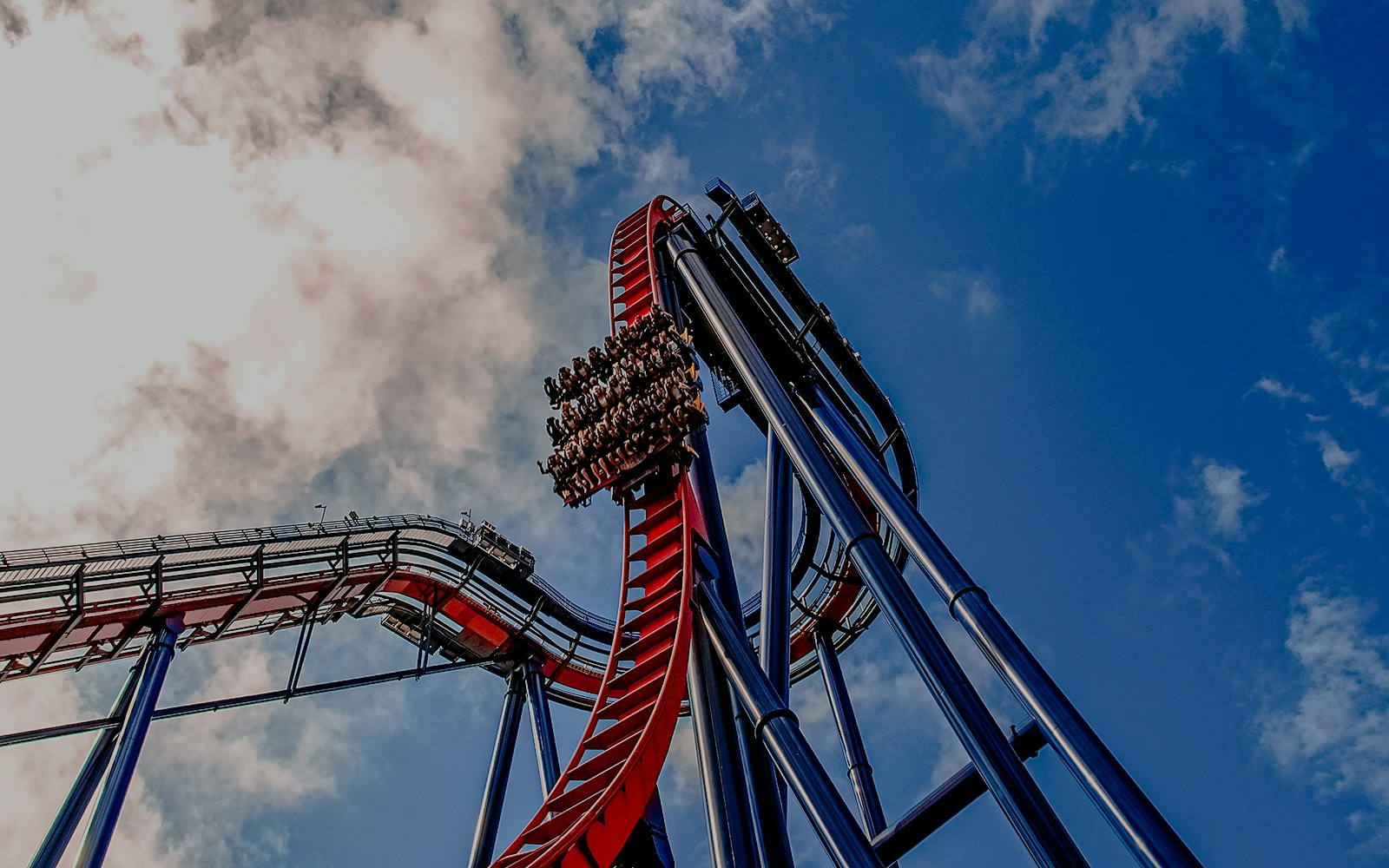 Roller coaster descent at Busch Gardens against a blue sky.