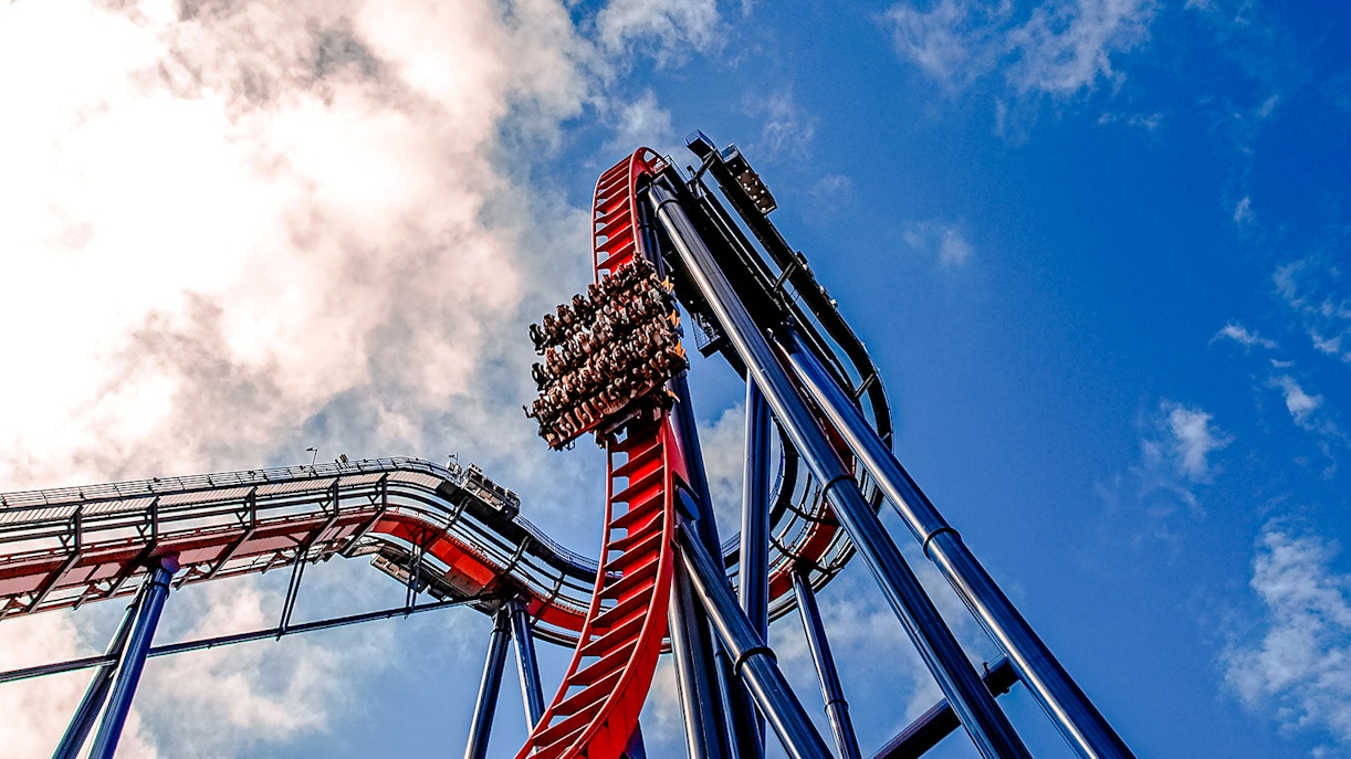 Roller coaster descent at Busch Gardens against a blue sky.