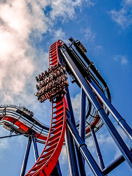 Roller coaster descent at Busch Gardens against a blue sky.