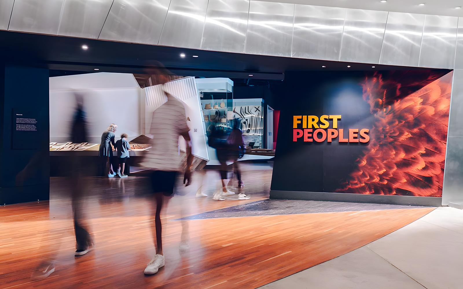 Bunjilaka First Peoples exhibit entrance at Melbourne Museum with visitors walking by.