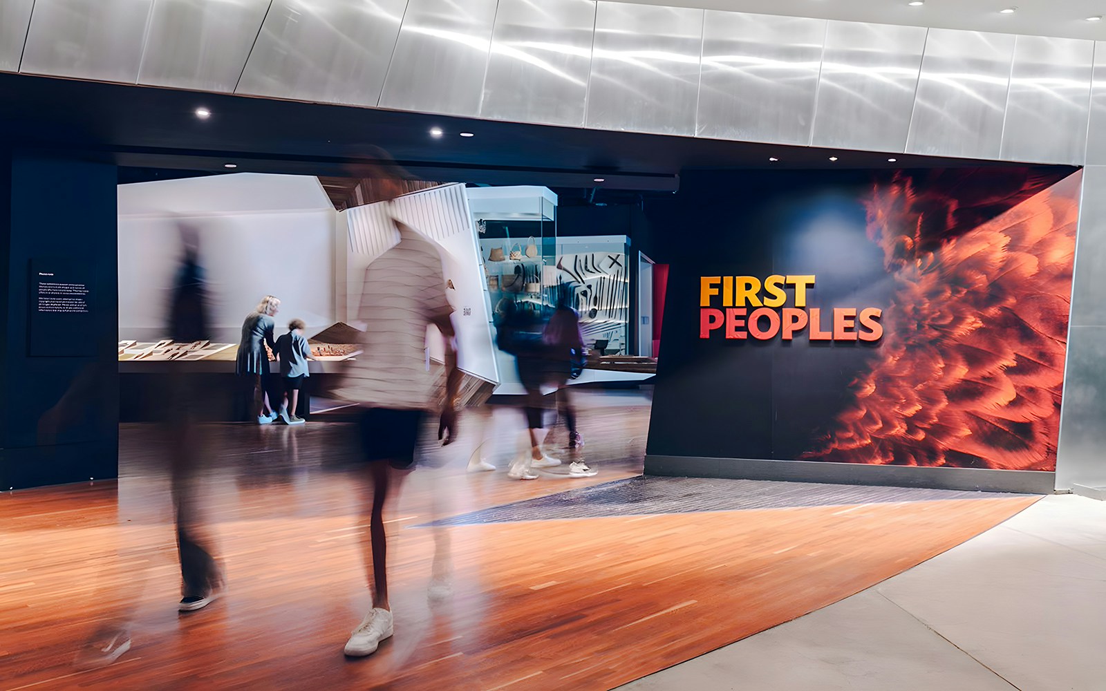 Bunjilaka First Peoples exhibit entrance at Melbourne Museum with visitors walking by.
