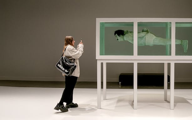 Visitor photographing an art installation at the Museum of Forbidden Art.