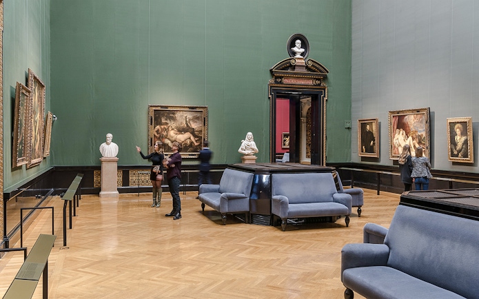 Guide explaining artwork inside Kunsthistorisches Museum, Vienna.