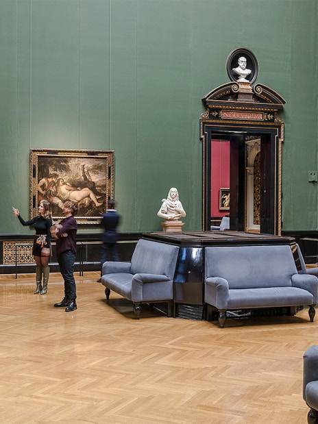 Guide explaining artwork inside Kunsthistorisches Museum, Vienna.