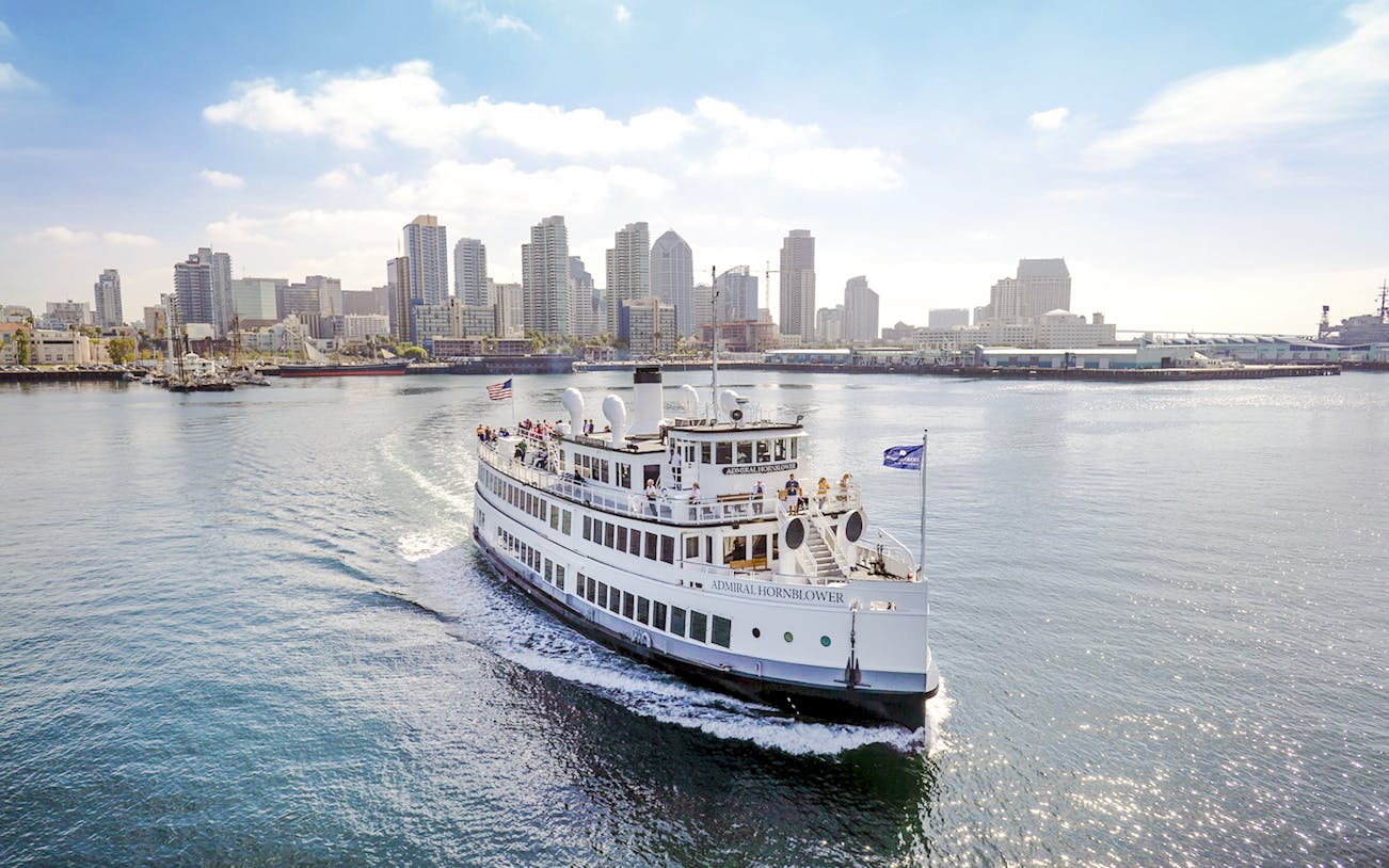 Harbor cruise ship sailing with San Diego skyline in the background.