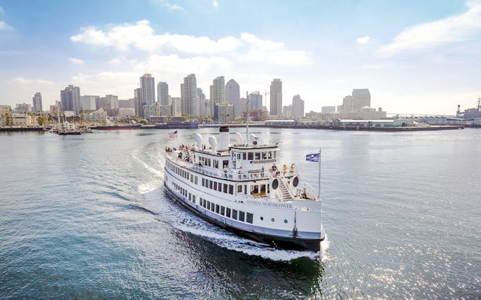 Harbor cruise ship sailing with San Diego skyline in the background.