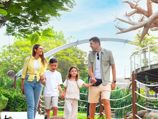 Family walking among ducks at Dubai Safari Park.