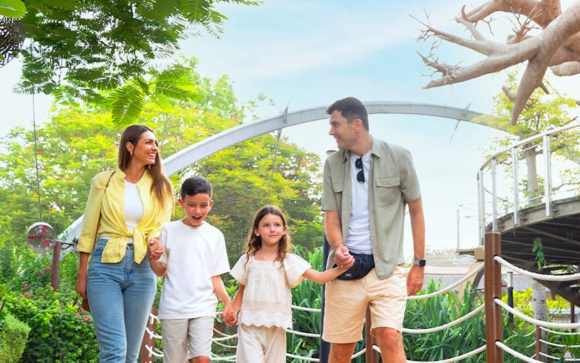 Family walking among ducks at Dubai Safari Park.