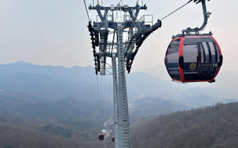 Cable car ascending Mutianyu Great Wall with mountain view in the background.