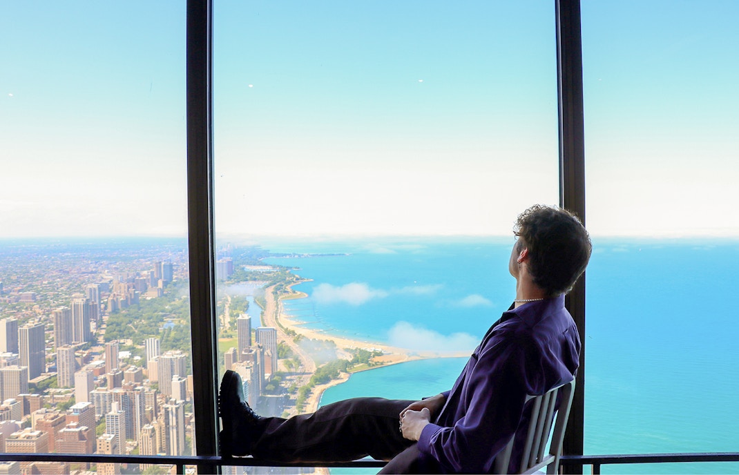A person sitting on a chair and enjoying the thrilling skyline views of Chicago